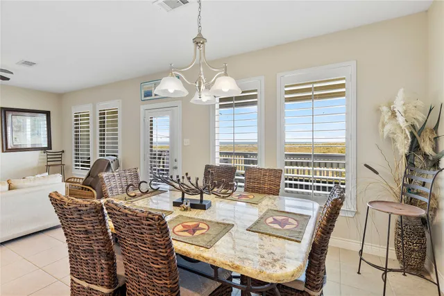 a dining room with furniture a chandelier and window