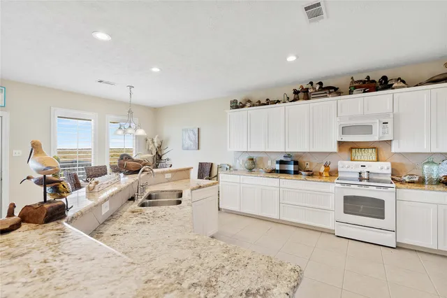 a large white kitchen with cabinets