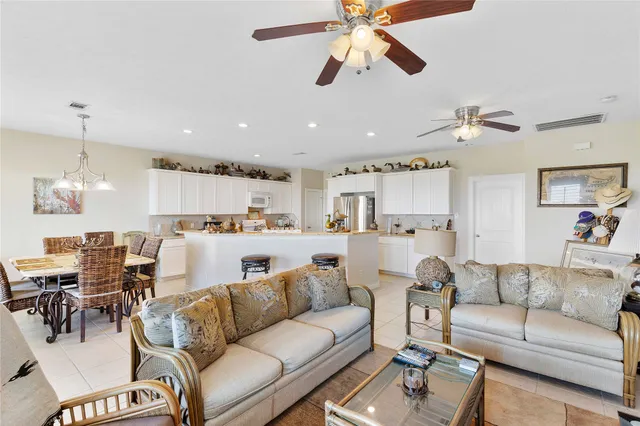 a living room with furniture kitchen view and a chandelier