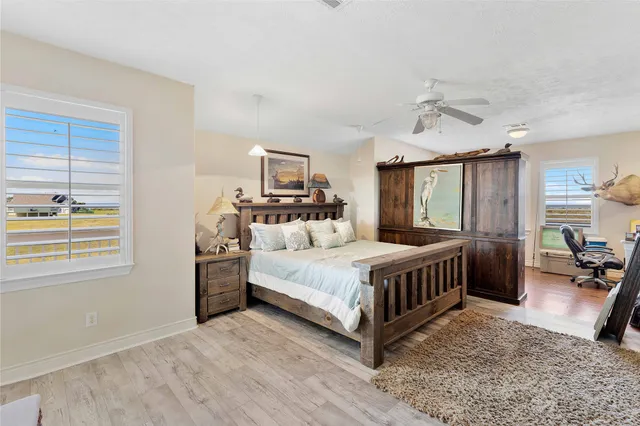 a bedroom with a bed wooden floor and window