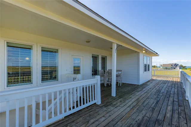 a view of backyard with deck and wooden floor