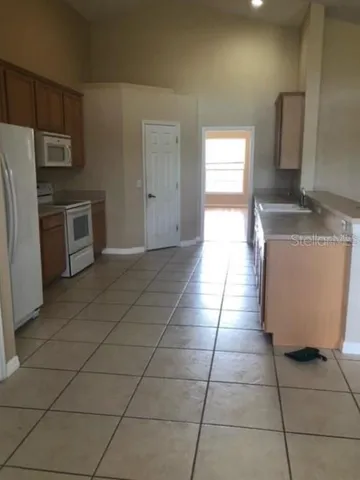 a kitchen with stainless steel appliances a sink a stove a microwave a counter top space and cabinets