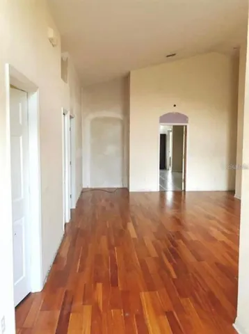 a view of empty room with wooden floor