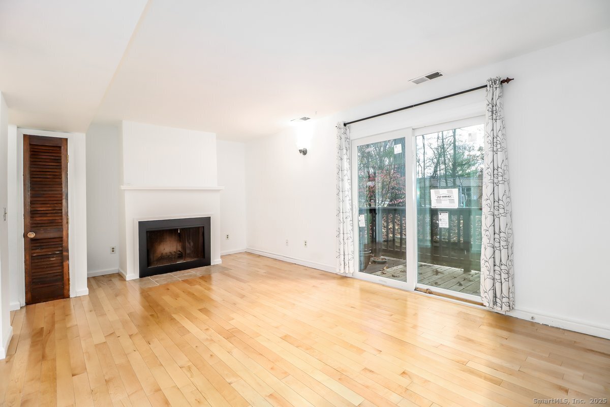 25 Padanaram Road, Unit 30 Danbury, CT 06811 - Photo 5 of 24 a view of an empty room with a fireplace and a window