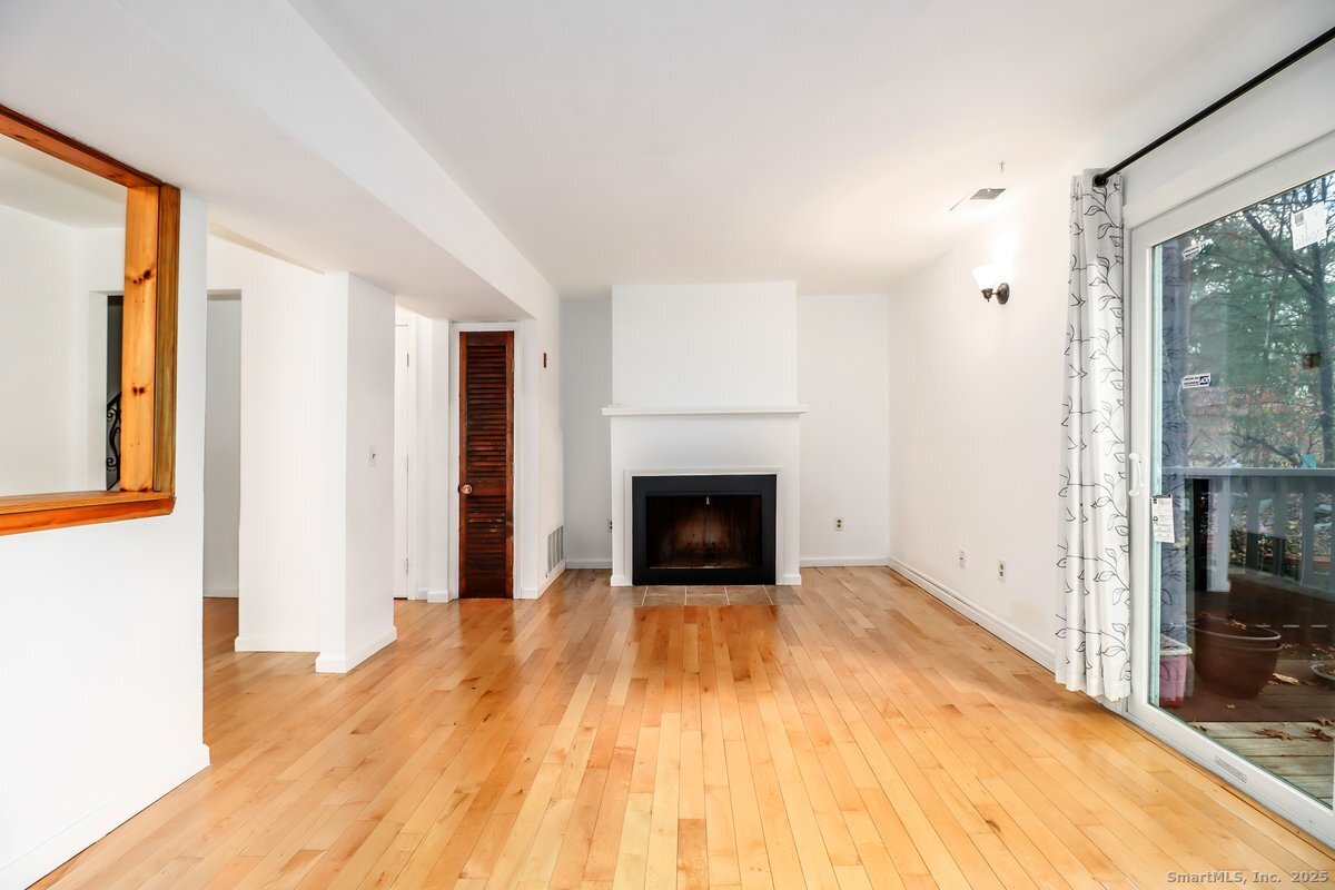25 Padanaram Road, Unit 30 Danbury, CT 06811 - Photo 6 of 24 a view of a livingroom with wooden floor and a fireplace