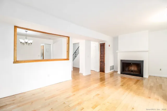 a view of a livingroom with wooden floor and a fireplace