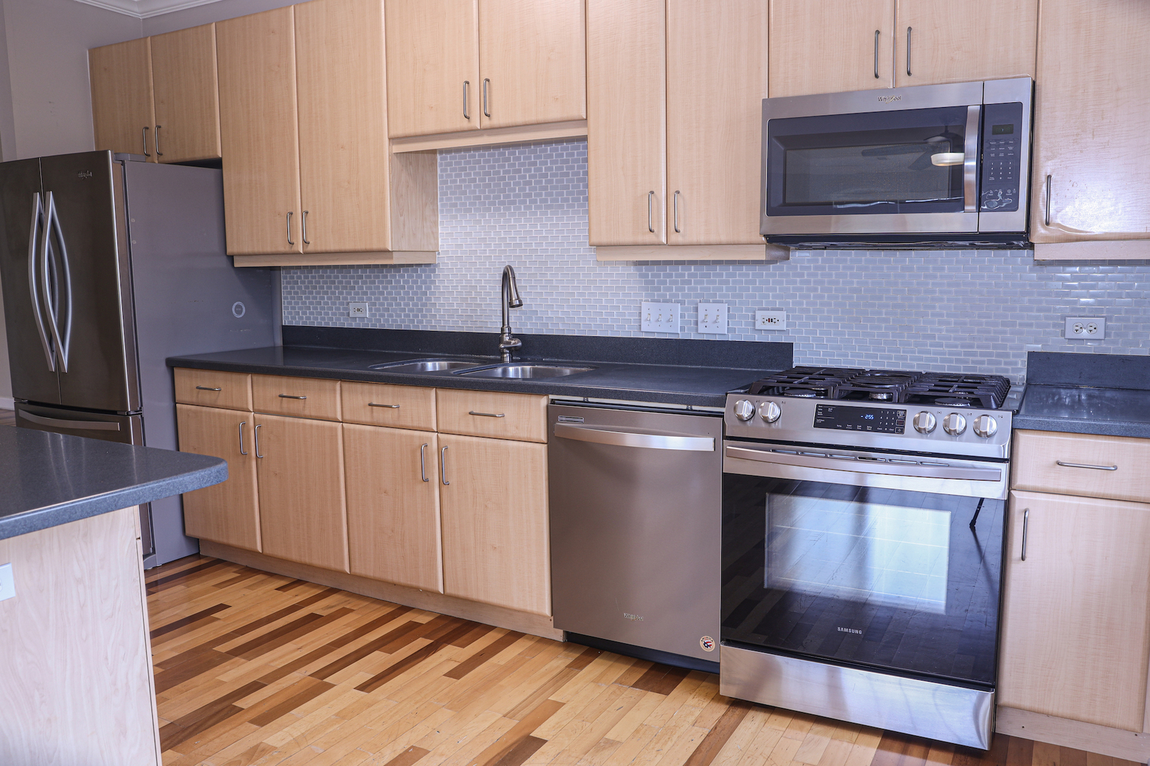 660 McHenry Road, Unit 204 Wheeling, IL 60090 - Photo 13 of 34 a kitchen with granite countertop cabinets stainless steel appliances and wooden floor