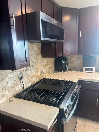a kitchen with a sink a stove and cabinets