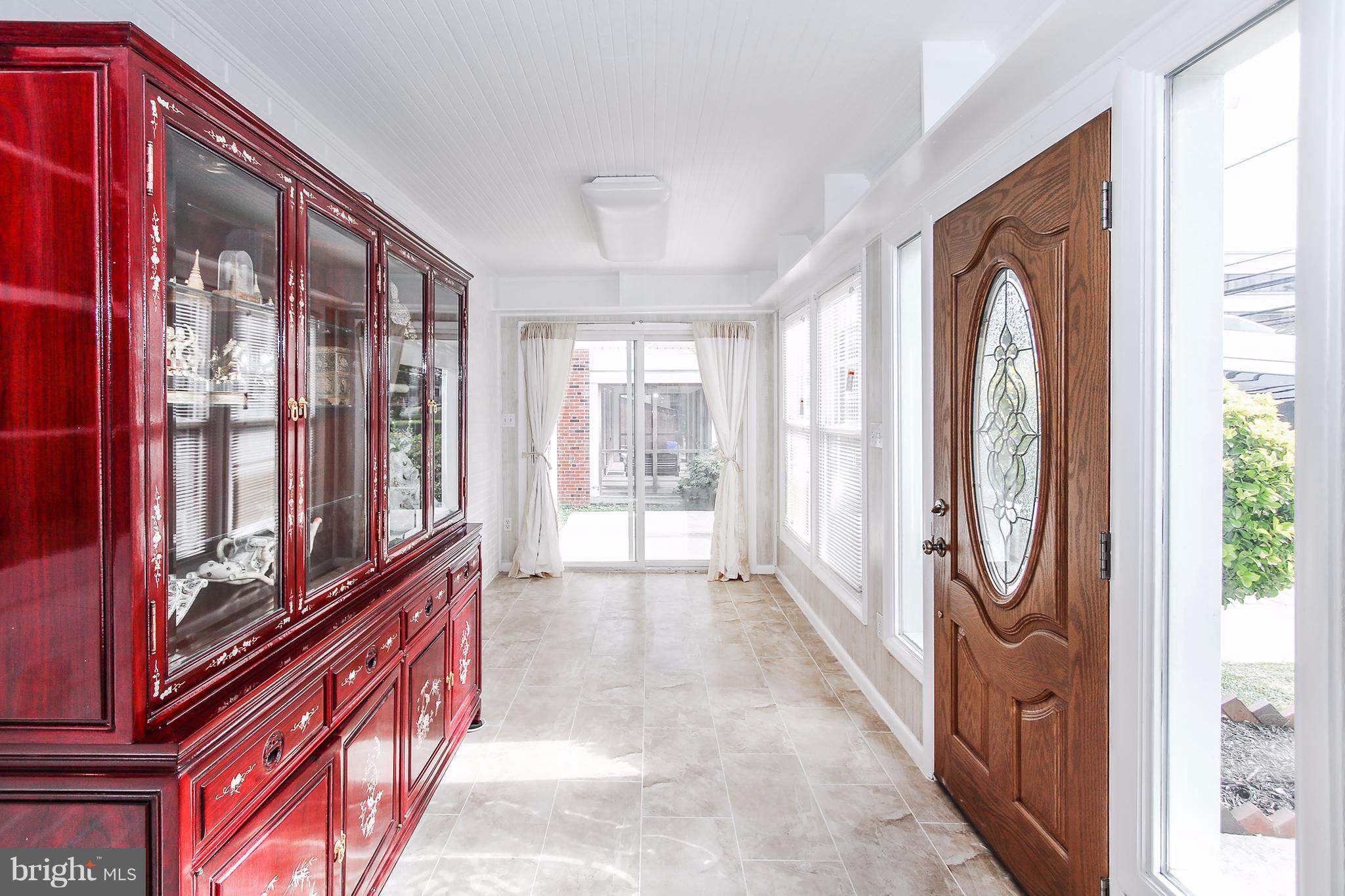 Enclosed front porch w/sliding door to driveway