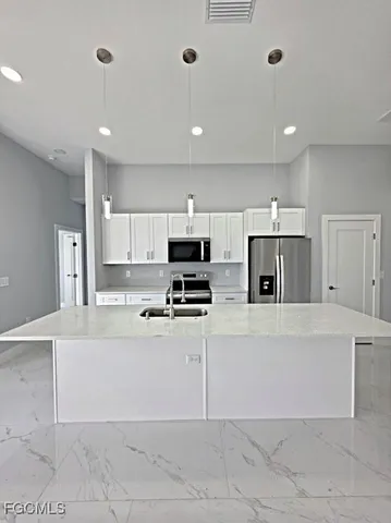 a kitchen with stainless steel appliances a refrigerator sink and stove