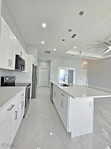 a large kitchen with stainless steel appliances granite countertop a lot of counter space and wooden floors
