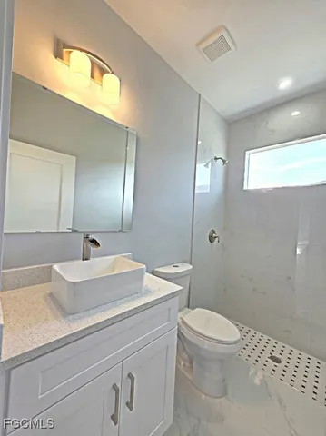 a bathroom with a sink a toilet a mirror and vanity