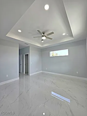 an empty room with a ceiling fan and window