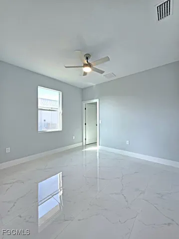 an empty room with fan and windows