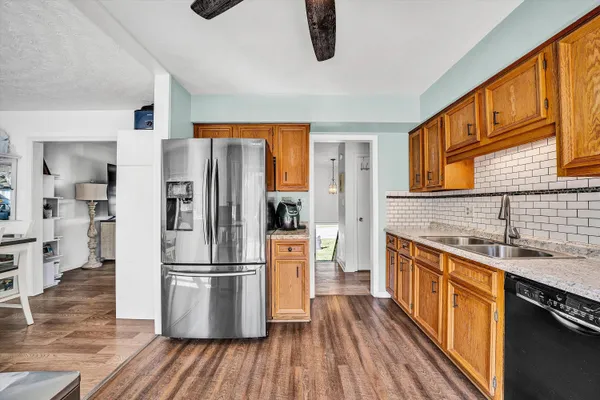 a kitchen with stainless steel appliances a refrigerator and wooden floor