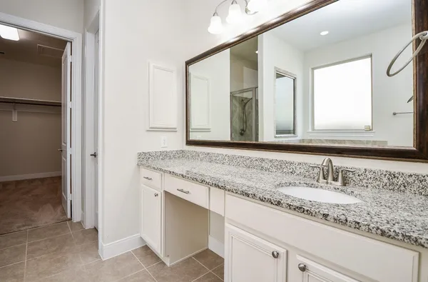 a bathroom with a granite countertop sink and a mirror