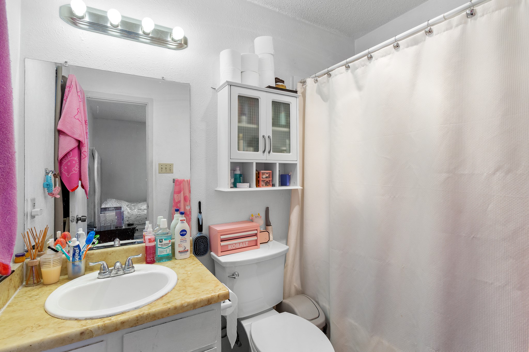 606 Misty Morning Way, Unit A AND B Round Rock, TX 78664 - Photo 14 of 22 En-suite bathroom featuring a shower with shower curtain, vanity, and a textured ceiling