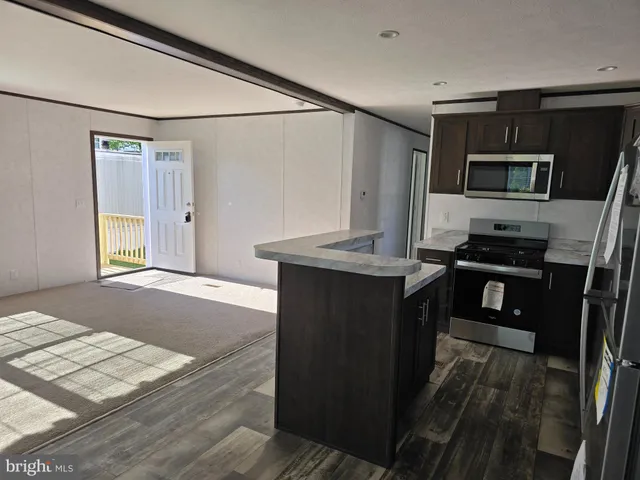 a kitchen with kitchen island a counter top space appliances and a sink