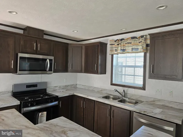 a kitchen with a sink stove top oven and refrigerator