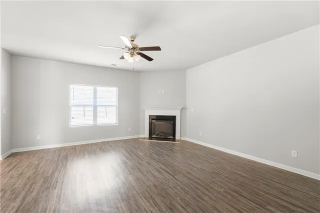 a view of an empty room with a fireplace and a window