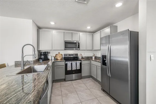 a kitchen with kitchen island a counter top space cabinets and stainless steel appliances