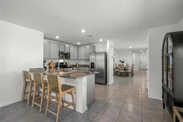 a kitchen with a refrigerator and a dining table