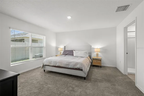 a spacious bedroom with a bed and a large window