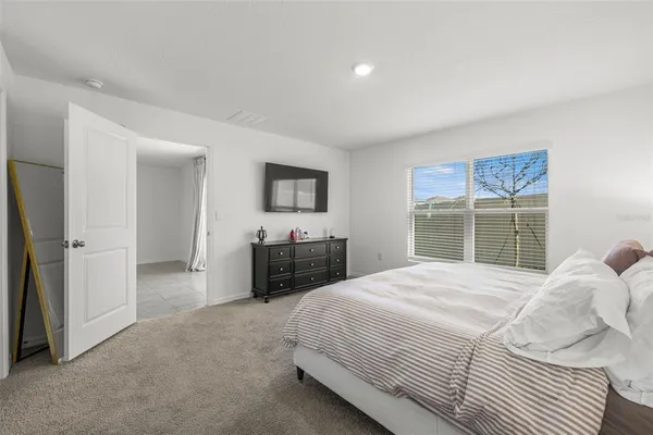 a bedroom with a bed and a large window
