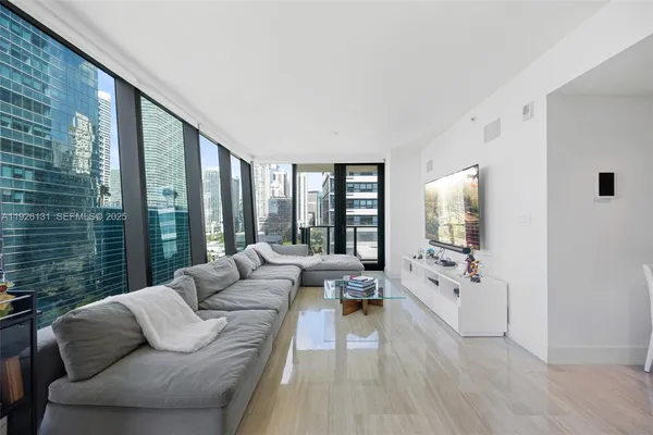 a living room with furniture and large windows