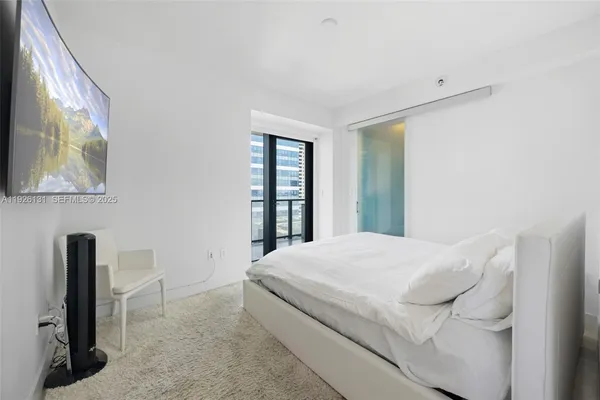 a bedroom with a bed and a large window