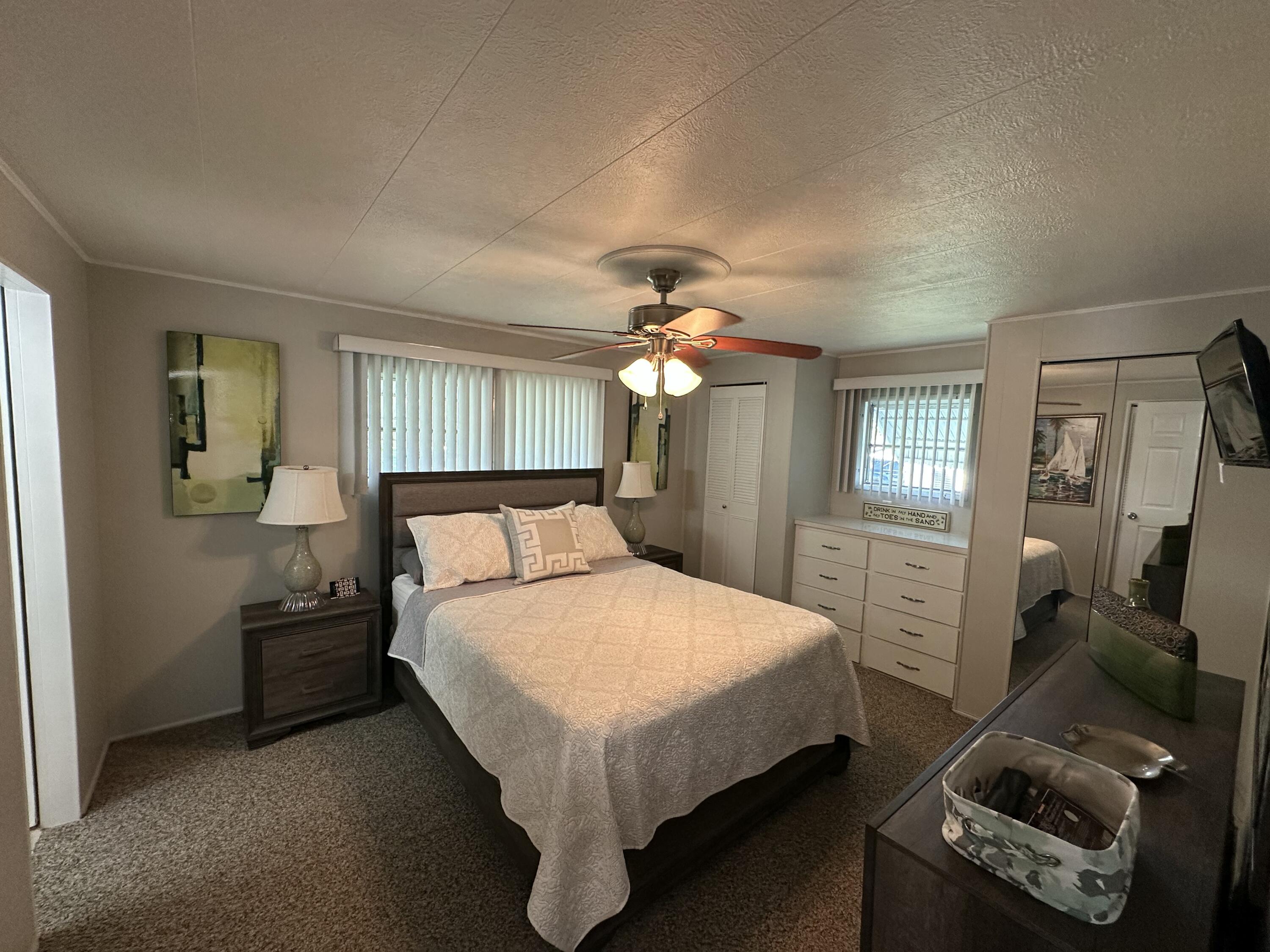 8281 South Street Boca Raton, FL 33433 - Photo 16 of 33 a bedroom with a bed and a chandelier