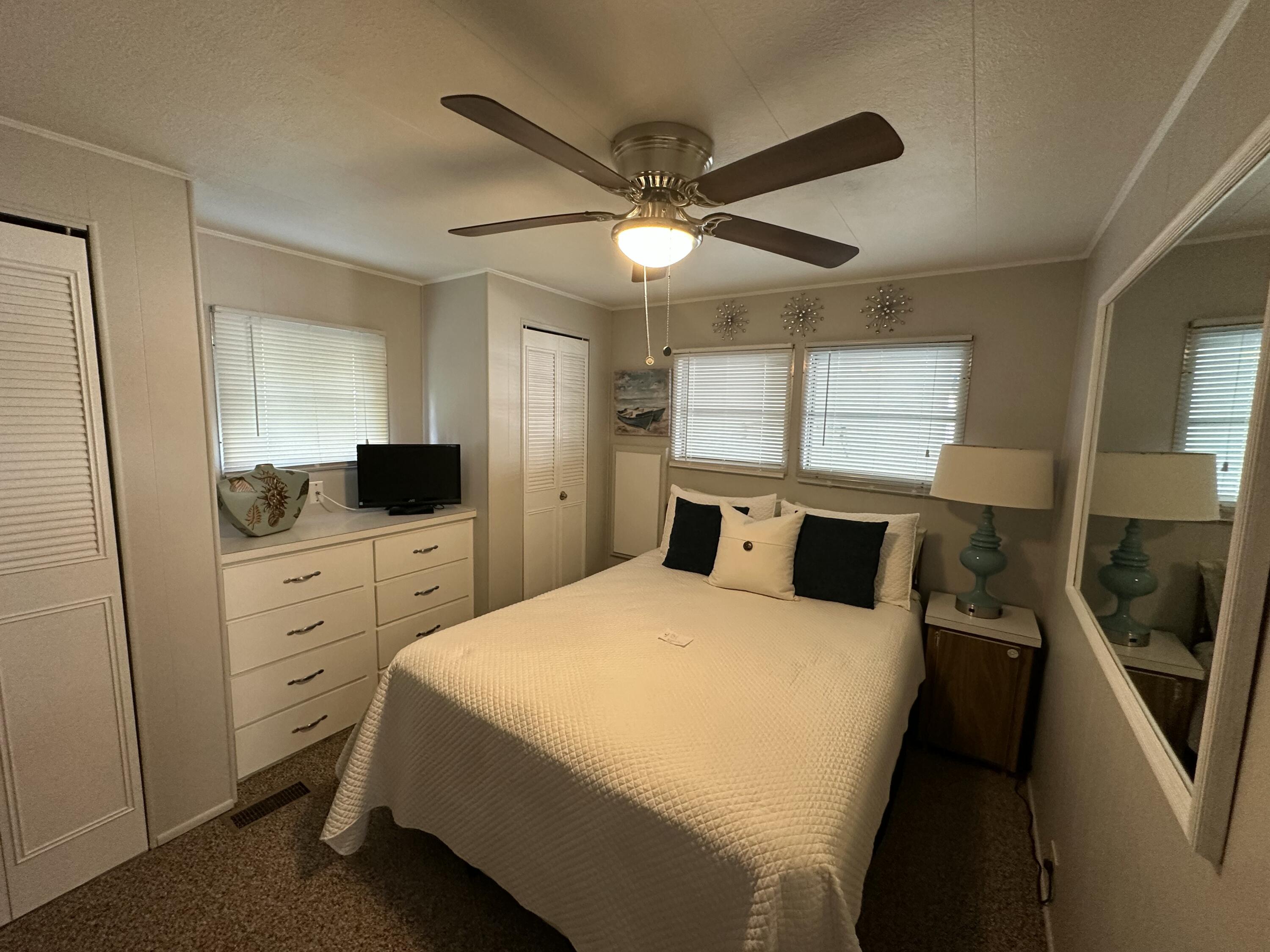 8281 South Street Boca Raton, FL 33433 - Photo 21 of 33 a bedroom with a bed and a flat tv screen on dresser