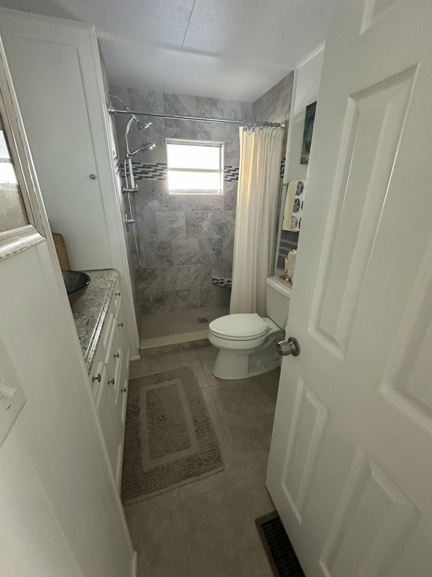8281 South Street Boca Raton, FL 33433 - Photo 24 of 33 a bathroom with a shower and toilet
