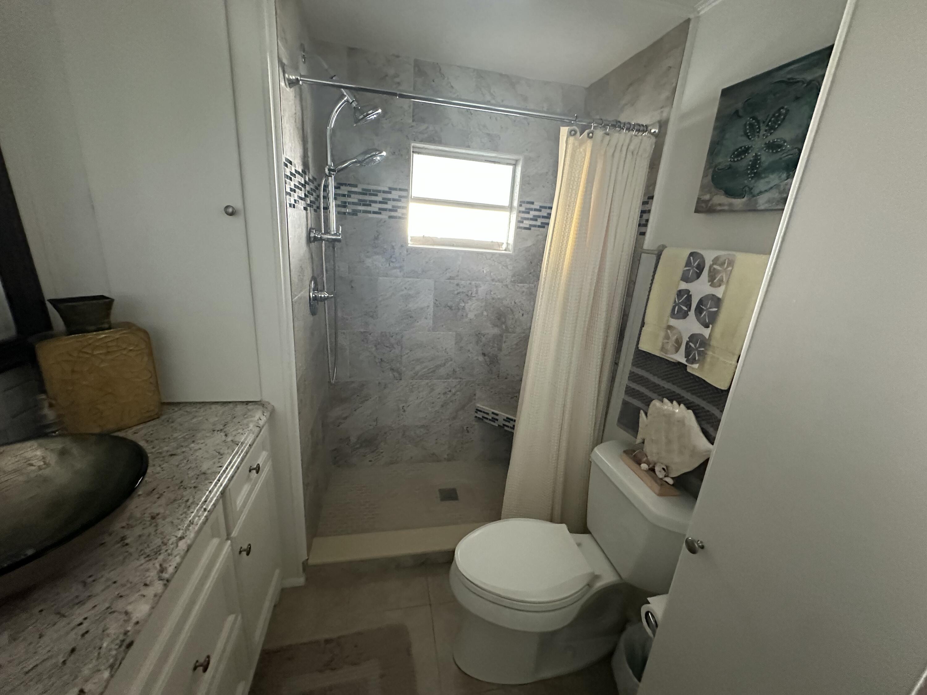 8281 South Street Boca Raton, FL 33433 - Photo 25 of 33 a bathroom with a granite countertop sink toilet and shower