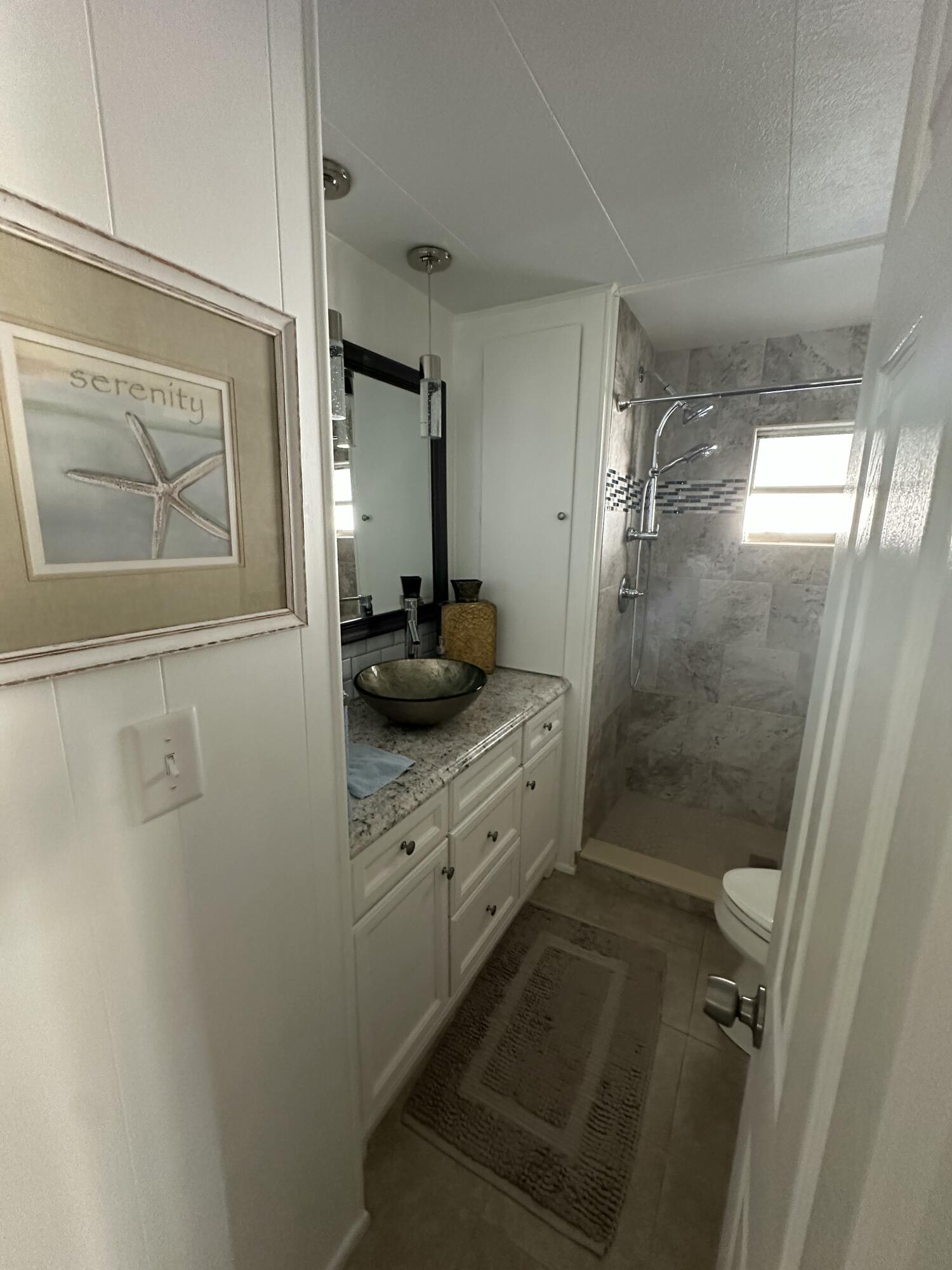 8281 South Street Boca Raton, FL 33433 - Photo 26 of 33 a bathroom with a granite countertop shower sink vanity and mirror