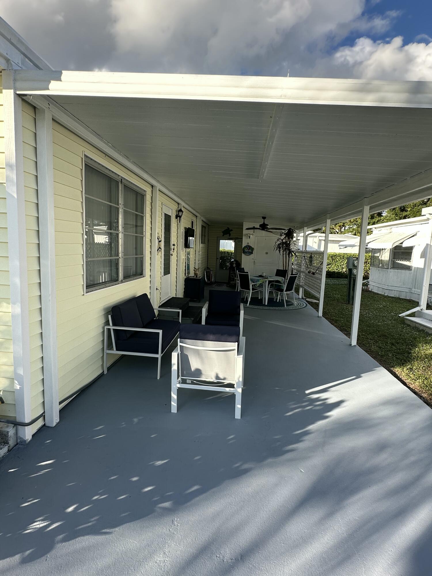 8281 South Street Boca Raton, FL 33433 - Photo 6 of 33 a view of a patio with table and chairs near a barn