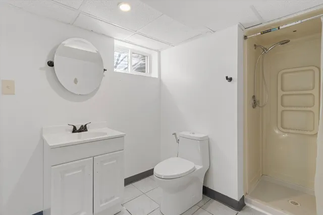 a bathroom with a toilet a sink a shower and mirror