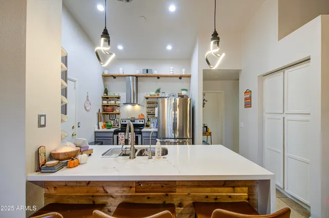 a room with kitchen island a sink and a refrigerator