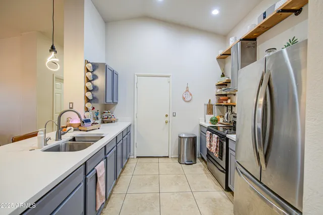 a kitchen with stainless steel appliances granite countertop a refrigerator and a sink