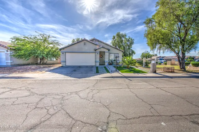 a view of a house with a yard and large tree