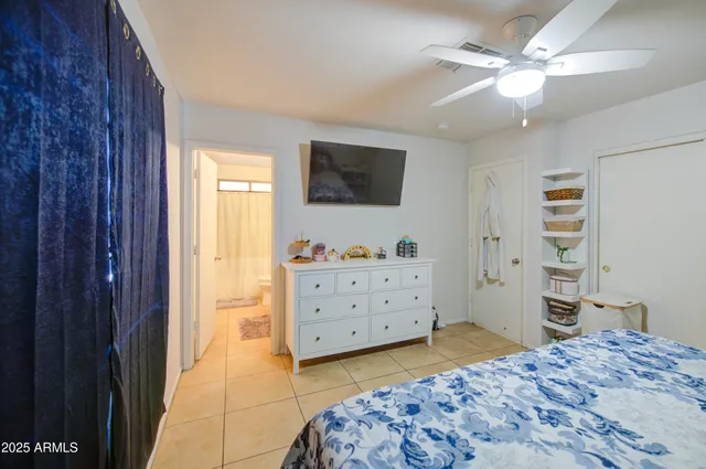 a bedroom with a bed and a flat tv screen on dresser