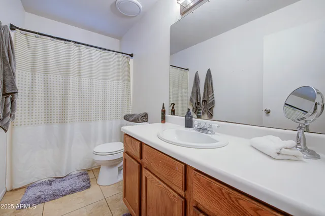 a bathroom with a sink a toilet and shower curtain