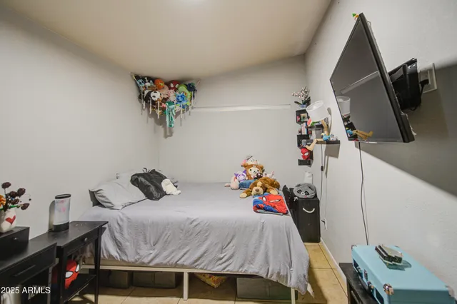 a bedroom with a bed a dresser and a flat screen tv