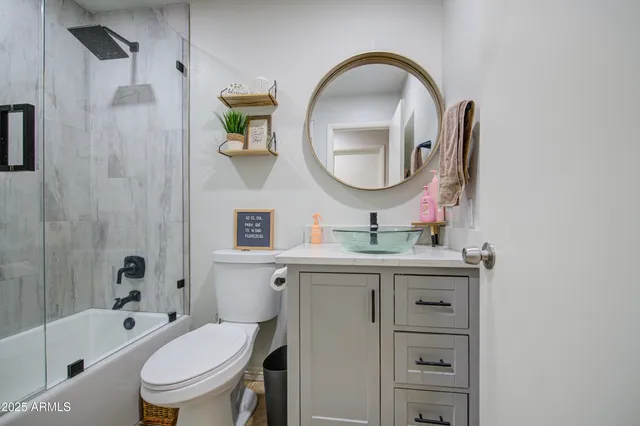 a bathroom with a granite countertop toilet a sink and a mirror