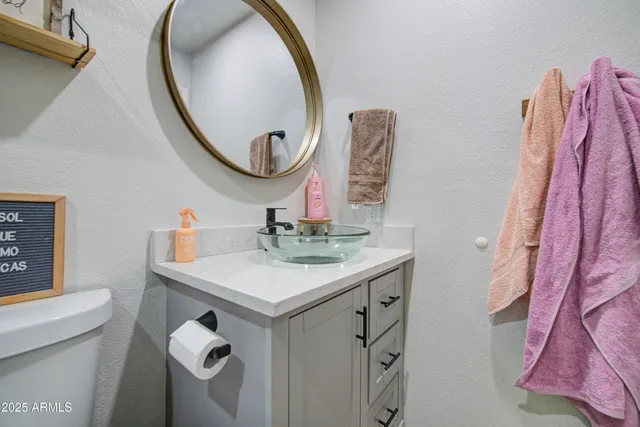 a bathroom with a sink vanity mirror and toilet