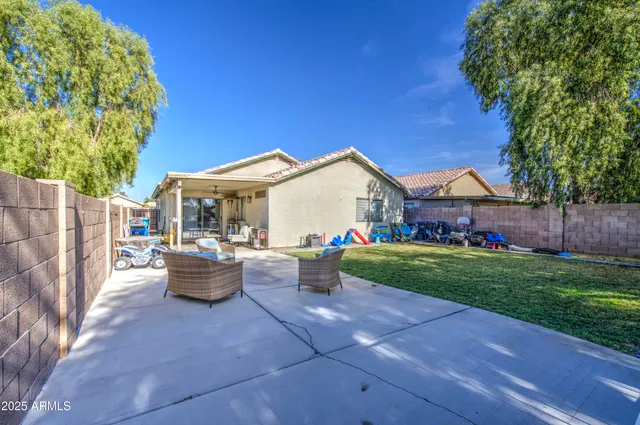 a view of a house with backyard and sitting area