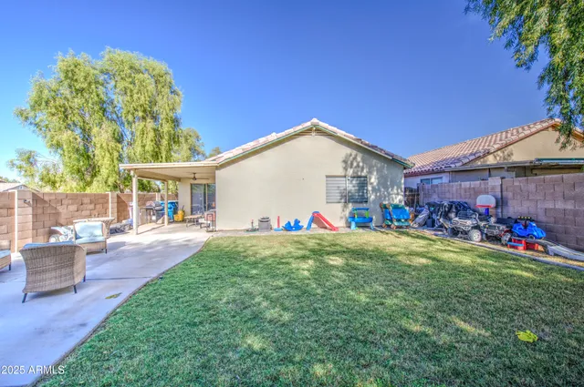 a view of a house with backyard and sitting area