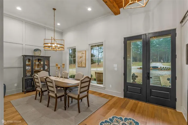 a spacious bathroom with a double vanity sink a two mirror a window and a bathtub