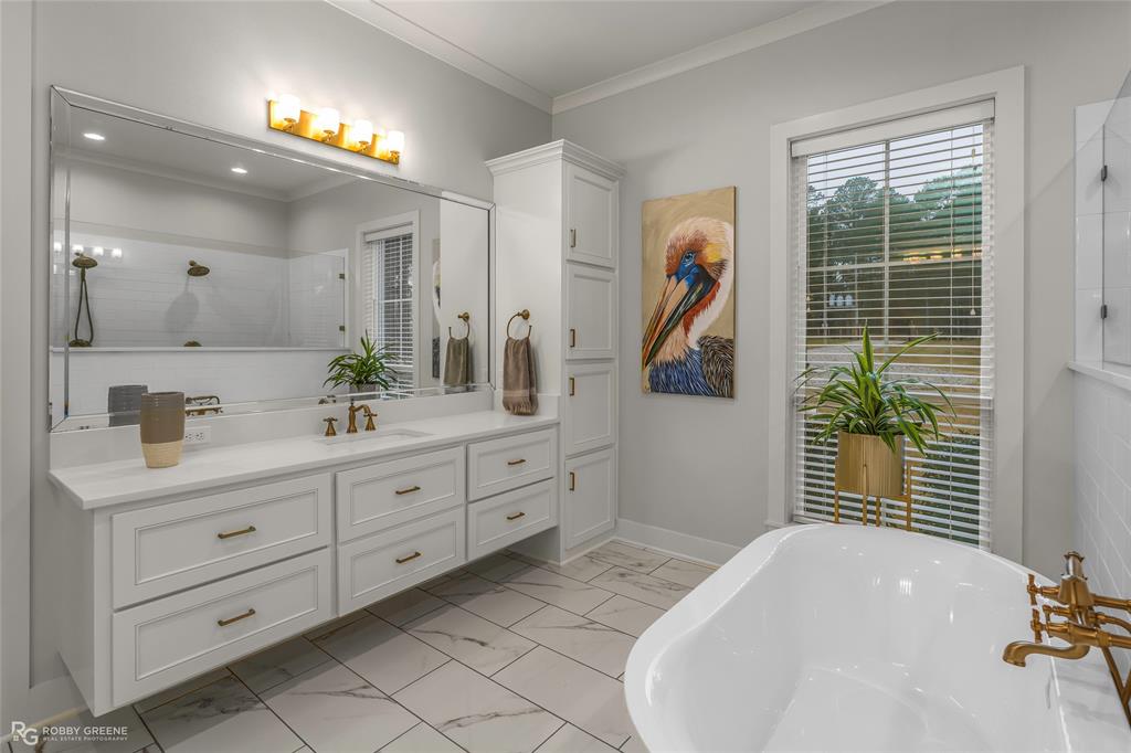 145 Crouch Road Benton, LA 71006 - Photo 15 of 40 a spacious bathroom with a double vanity sink a two mirror a window and a bathtub