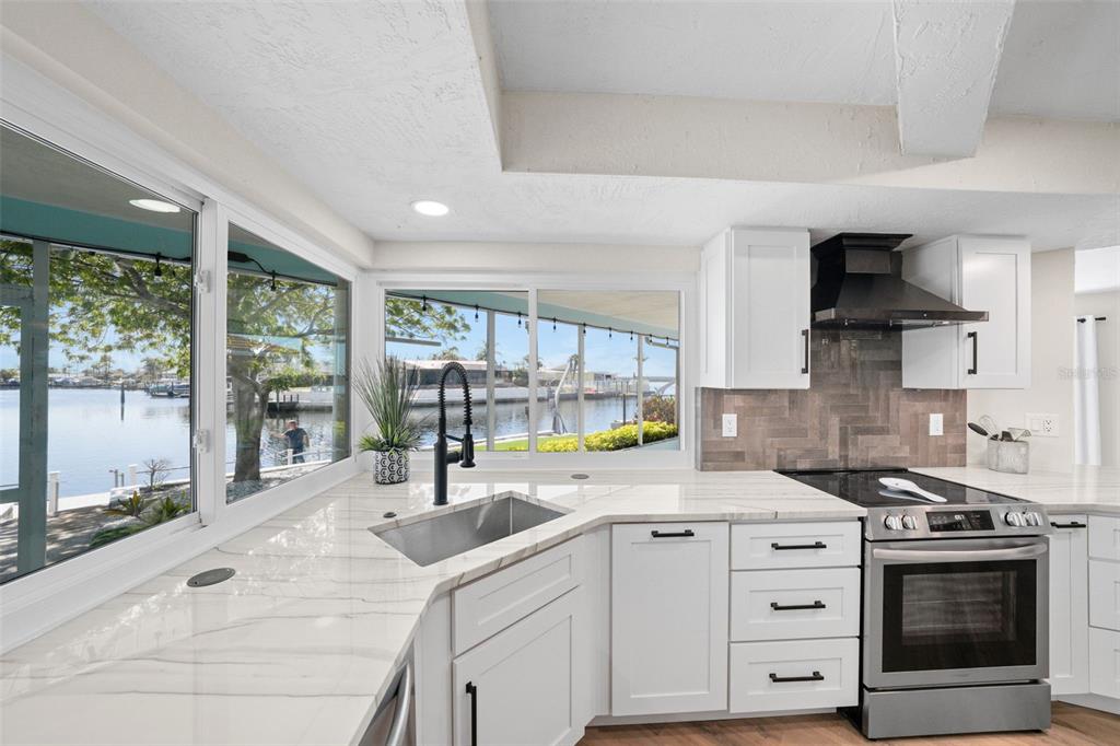 4968 South Shore Drive New Port Richey, FL 34652 - Photo 4 of 60 a kitchen with stainless steel appliances a stove sink and cabinets
